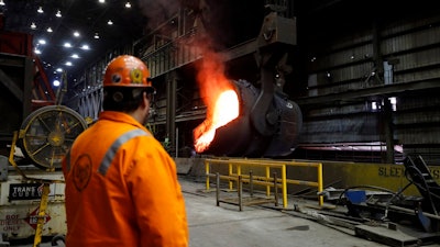 In this Thursday, June 28, 2018, file photo senior melt operator Randy Feltmeyer watches a giant ladle as it backs away after pouring its contents of red-hot iron into a vessel in the basic oxygen furnace as part of the process of producing steel at the U.S. Steel Granite City Works facility in Granite City, Ill. On Monday, July 2, the Institute for Supply Management, a trade group of purchasing managers, issues its index of manufacturing activity for June.