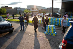 Emergency response teams hand out free bottled water to residents at the Parchment High School in Parchment, Mich., Friday, July 27, 2018. Authorities handed out thousands of free bottles of water Friday for two southwestern Michigan communities where the discovery of contamination from toxic industrial chemicals prompted a warning against using the public water system for drinking or cooking.