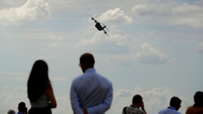 Spectators watch an Airbus 400M take part in a flying display at the Farnborough Airshow in Farnborough, England, Monday, July 16, 2018.