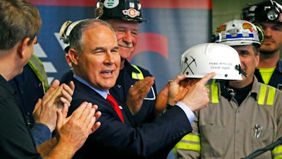 In this April 13, 2017, file photo, Environmental Protection Agency Administrator Scott Pruitt holds up a hardhat he was given during a visit to Consol Pennsylvania Coal Company's Harvey Mine in Sycamore, Pa. Pruitt moved to roll back environmental regulations affecting many industries. Pruitt proposed last year to repeal a key climate-change regulation of President Barack Obama’s administration, which aimed to reduce emissions of carbon-trapping gases from coal-fired power plants.