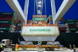 In this June, 19, 2018, file photo, an Evergreen Line refrigerated container is lifted by a ship to shore crane onto the container ship Ever Linking at the Port of Savannah in Savannah, Ga. The U.S. trade deficit dropped in May to the lowest level in 19 months as U.S. exports rose to a record level. But the trade gap between the United States and China increased sharply, underscoring the economic tensions between the world’s two biggest economies.