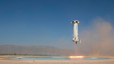 In this photo provided by Blue Origin, The booster of the New Shepard rocket prepares to land in a project called Mission 9 (M9) in western Texas on Wednesday, July 18, 2018. Jeff Bezos' Blue Origin rocket company shot a capsule higher into space Wednesday than it's ever done before.