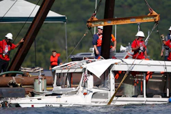 In this July 23, 2018, file photo, the duck boat that sank in Table Rock Lake in Branson, Mo., is raised. A lawsuit seeking $100 million in damages was filed Sunday, July 29, against the owners and operators of the duck boat that sank July 19.