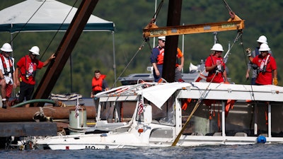 In this July 23, 2018, file photo, the duck boat that sank in Table Rock Lake in Branson, Mo., is raised. A lawsuit seeking $100 million in damages was filed Sunday, July 29, against the owners and operators of the duck boat that sank July 19.