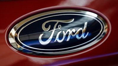 This Feb. 15, 2018, file photo shows a Ford logo on a vehicle at the Pittsburgh Auto Show in Pittsburgh. Ford is recalling about 550,000 cars and SUVs in North America to fix a gearshift problem that could cause the vehicles to roll away unexpectedly. The recall covers certain 2013 through 2016 Fusion sedans and some 2013 and 2014 Escape small SUVs. Owners will be notified by July 30.