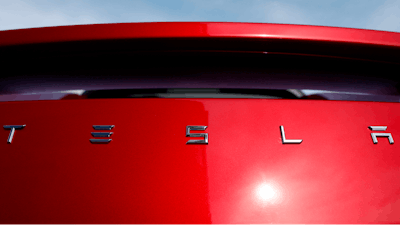In this April 15, 2018, file photo, the sun shines off the rear deck of a roadster on a Tesla dealer's lot in the south Denver suburb of Littleton, Colo. Tesla stock is sinking Monday, July 23, after the Wall Street Journal reported that the company asked suppliers for refunds to help it turn a profit.
