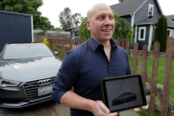 In this June 27, 2018, photo, Christian Kingery poses for photo at his home in Preston, Wash., near Seattle, next to the leased Audi he is driving until he can take delivery of a long-awaited Tesla Model 3, which is shown on his tablet computer. Kingery, who is on an official waiting list for his car, says Tesla has told him it could take until between September and November of 2018 for his car to be delivered, but he fears it might be even longer.