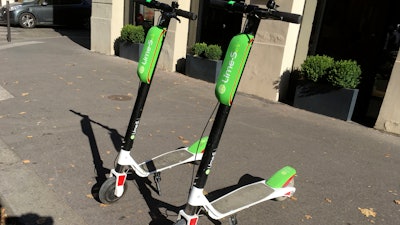 This July 3, 2018, photo shows scooters by Lime in Paris. Uber is getting into the scooter-rental business. The ride-hailing company said Monday, July 9, that it is investing in Lime, a startup based in San Mateo, California.