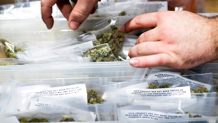 In this Jan. 6, 2018, file photo, an employee stocks cannabis at a store shortly before its first day of recreational marijuana sales in San Francisco. California cities on Monday, Aug. 13, 2018, objected to a proposed change in state rules that they say would allow unchecked home marijuana deliveries in places that have banned local pot sales.