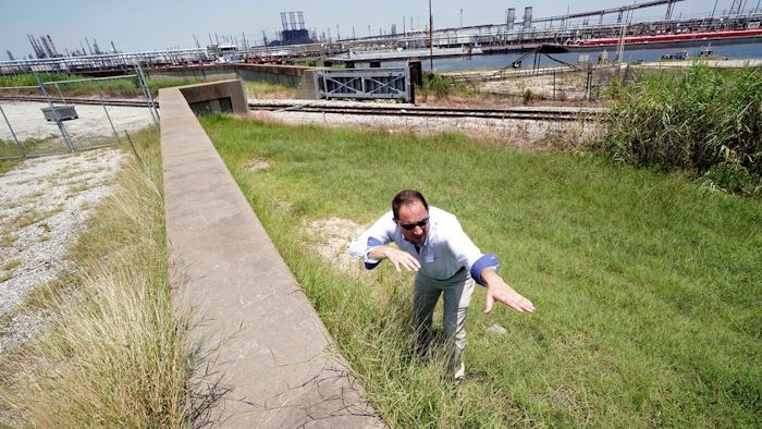 Resident Engineer Steve Sherrill, with the US Army Corps of Engineers, shows how much height will be added to some of the levees and seawalls near a refinery Thursday, July 26, 2018, in Port Arthur, Texas. The oil industry wants the government to help protect some of its facilities on the Texas Gulf Coast against the effects of global warming. One proposal involves building a nearly 60-mile “spine” of flood barriers to shield refineries and chemical plants. Many Republicans argue that such projects should be a national priority. But others question whether taxpayers should have to protect refineries in a state where top politicians still dispute whether climate change is real.
