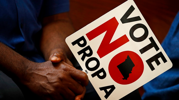 In this Tuesday, July 31, 2018, file photo, people opposing Proposition A listen to a speaker during a rally in Kansas City, Mo. Missouri votes Tuesday, Aug. 7 on a so-called right-to-work law, a voter referendum seeking to ban compulsory union fees in all private-sector workplaces.