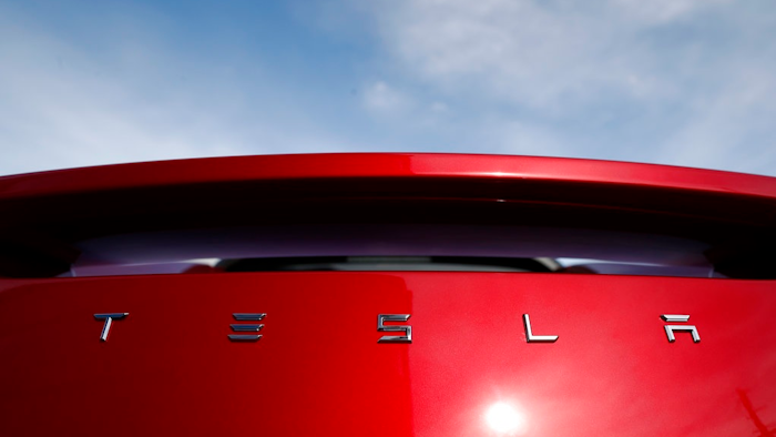 In this April 15, 2018, file photo, the sun shines off the rear deck of a roadster on a Tesla dealer's lot in the south Denver suburb of Littleton, Colo. Tesla’s second-quarter revenue should grow by more than $1 billion as it delivered more Model 3 electric cars. But analysts predict it won’t be enough to stop the company’s net loss from rising dramatically when the Palo Alto, Calif., company reports earnings after the bell Wednesday, Aug. 1.