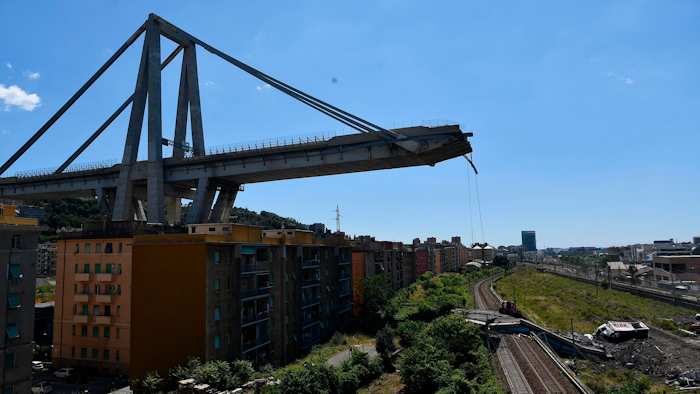 A view of the evacuated houses built under the remains part of the collapsed Morandi highway bridge, in Genoa, northern Italy, Wednesday, Aug. 15, 2018. A bridge on a main highway linking Italy with France collapsed in the Italian port city of Genoa during a sudden, violent storm, sending vehicles plunging 90 meters (nearly 300 feet) into a heap of rubble below.