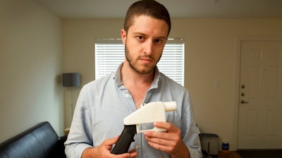 In this May 10, 2013, file photo, Cody Wilson, the founder of Defense Distributed, shows a plastic handgun made on a 3D-printer at his home in Austin, Texas. Eight states filed suit Monday, July 30, 2018, against the Trump administration over its decision to allow a Texas company to publish downloadable blueprints for a 3D-printed gun, contending the hard-to-trace plastic weapons are a boon to terrorists and criminals and threaten public safety.