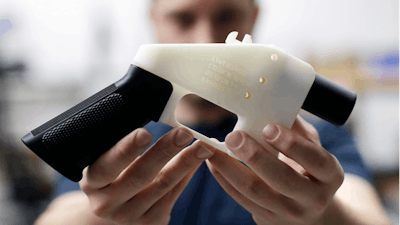 In this Aug. 1, 2018, file photo, Cody Wilson, with Defense Distributed, holds a 3D-printed gun called the Liberator at his shop in Austin, Texas. A federal judge in Seattle has granted an injunction that prohibits the Trump administration from allowing a Texas company to post 3D gun-making plans online.