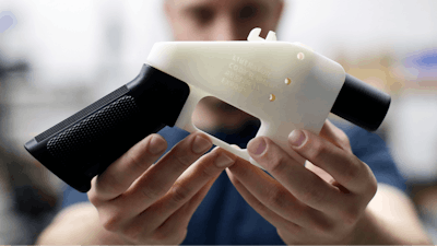 In this Aug. 1, 2018, file photo, Cody Wilson, with Defense Distributed, holds a 3D-printed gun called the Liberator at his shop in Austin, Texas. A federal judge in Seattle has granted an injunction that prohibits the Trump administration from allowing a Texas company to post 3D gun-making plans online.