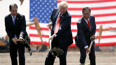 In this June 28, 2018, file photo, President Donald Trump, center, along with Wisconsin Gov. Scott Walker, left, and Foxconn Chairman Terry Gou participate in a groundbreaking event for the new Foxconn facility in Mt. Pleasant, Wis. To make the next generation of liquid crystal display technology, Foxconn Technology Group will draw talent from beyond the borders of Wisconsin, partner with universities and technical schools and even tap into transitioning members of the military to find the 13,000 workers it eventually expects to hire.