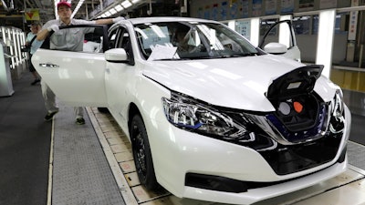 A worker inspects a Nissan Sylphy Zero Emission, Nissan's first all-electric vehicle built in China, at a production line in Guangzhou, Guangdong province, China, Monday, Aug. 27, 2018. The Sylphy is part of a wave of dozens of electric models planned by global automakers for China where the government is pressing them to accelerate development of the technology.