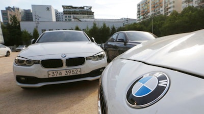 BMW cars are parked for an emergency safety check at the playground of an elementary school near a BMW service center in Seoul, South Korea, Tuesday, Aug. 14, 2018. South Korea will ban driving recalled BMWs that haven't received safety checks following dozens of fires the German automaker has blamed on a faulty exhaust gas component.