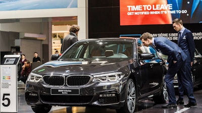 In this Jan. 13, 2017, file photo men look at a BMW 5 series during the media day of the 95th European Motor Show in Brussels. The Insurance Institute for Highway Safety, in a paper titled “Reality Check,” issued the warning Tuesday, Aug. 7, 2018, after testing five of the systems from Tesla, Mercedes, BMW and Volvo on a track and public roads. The systems tested, in the Tesla Model 3 and Model S, BMW’s 5-Series, the Volvo S-90 and the Mercedes E-Class, are among the best in the business right now and have been rated “superior” in previous IIHS tests. David Zuby, the institute’s chief research officer, said the systems do increase safety but the tests show they are not 100 percent reliable.