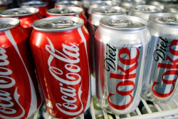 In this March 17, 2011, file photo, cans of Coca-Cola and Diet Coke sit in a cooler at a deli in Portland, Ore. Items ranging from canned beverages to airline tickets will likely get more expensive, companies warn, as they face higher costs. Procter & Gamble, one of the biggest makers of consumer products, said Tuesday, July 31, 2018, that Pampers prices will increase by an average of 4 percent in North America, while the Bounty, Charmin and Puffs brands could see 5 percent increases.