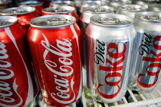 In this March 17, 2011, file photo, cans of Coca-Cola and Diet Coke sit in a cooler at a deli in Portland, Ore. Items ranging from canned beverages to airline tickets will likely get more expensive, companies warn, as they face higher costs. Procter & Gamble, one of the biggest makers of consumer products, said Tuesday, July 31, 2018, that Pampers prices will increase by an average of 4 percent in North America, while the Bounty, Charmin and Puffs brands could see 5 percent increases.