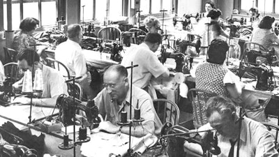 In this June 28, 1944, file photo, garment workers sew clothing at a loft factory in New York. Hundreds of thousands of garment workers once toiled in the sweaty, elbow-to-elbow workshops of midtown Manhattan before the whirring of sewing machines was mostly silenced by foreign competition. But a group of New Yorkers - manufacturers, landlords, designers, politicians - want to preserve some of the bustling sewing scene by zoning the neighborhood for at least 300,000 square feet of garment workshops now serving higher-end designers.