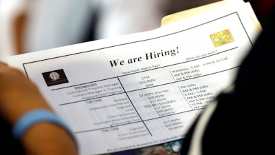 In this June 21, 2018 file photo, a job applicant looks at job listings for the Riverside Hotel at a job fair hosted by Job News South Florida, in Sunrise, Fla.