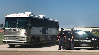 An ICE bus pulls out of a tomato plant in O'Neill, Neb., after an immigration raid at the plant Wednesday, Aug. 8, 2018. A large federal law enforcement operation conducted Wednesday targeted businesses in Nebraska and Minnesota that officials say knowingly hired - and mistreated - immigrants who are in the U.S. illegally.