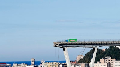 A view of the Morandi highway bridge that collapsed in Genoa, northern Italy, Wednesday, Aug. 15, 2018. A large section of the bridge collapsed over an industrial area in the Italian city of Genova during a sudden and violent storm, leaving vehicles crushed in rubble below.