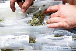 In this Jan. 6, 2018, file photo, an employee stocks cannabis at a store shortly before its first day of recreational marijuana sales in San Francisco. California cities on Monday, Aug. 13, 2018, objected to a proposed change in state rules that they say would allow unchecked home marijuana deliveries in places that have banned local pot sales.