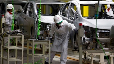 In this Feb. 21, 2014 file photo, employees at work in the new multibillion-dollar Honda car plant in Celaya, in the central Mexican state of Guanajuato. Many in the U.S. government, and even some in Mexico, say the new trade agreement reached in Aug. 2018, between the two countries will help increase the extremely low wages in Mexico's auto industry.