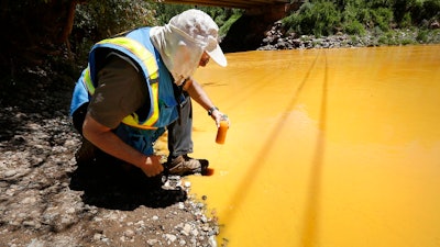 In this Aug. 6, 2015, file photo, Dan Bender of the La Plata County Sheriff's Office takes a water sample from the Animas River near Durango, Colo., after the U.S. Environmental Protection Agency accidentally triggered a spill of 3 million gallons of wastewater from the mine. The Obama administration said it could not legally repay any of the claims for damage from the spill, but the Trump administration promised last year to reconsider. As of Friday, Aug. 3, 2018, no claims had been paid, but the agency said it is continuing to review them.