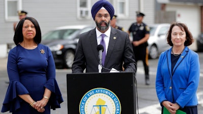 New Jersey Attorney General Gurbir Grewal, center, stands with Lt. Gov. Sheila Oliver, left, and state Environmental Protection Commissioner Catherine McCabe during a news conference announcing pollution lawsuits filed by the state, Wednesday, Aug. 1, 2018, in Newark, N.J. Grewal said it's the largest single-day action the state has taken in at least a decade and the first new natural resources damages case since 2008. He said he didn't have an estimate for what the state might recover financially but said the cases could take a long time to prosecute. The cases include two sites in Newark, two in Woodbridge and one each in Atlantic City and Warren County.