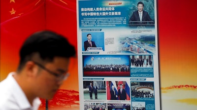 A man walks by a government propaganda billboard promoting Chinese President Xi Jinping's signature 'One Belt One Road' outside a subway station in Beijing, Tuesday, Aug. 28, 2018. Chinese officials on Monday defended Beijing's initiative to build a 'New Silk Road' of railways and other infrastructure across Asia against complaints it leaves host countries with too much debt after Malaysia canceled two high-profile projects. The officials said President Xi Jinping's signature foreign policy initiative is creating assets that are needed by developing countries but might take time to pay off.