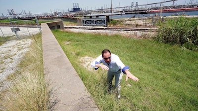 Resident Engineer Steve Sherrill, with the US Army Corps of Engineers, shows how much height will be added to some of the levees and seawalls near a refinery Thursday, July 26, 2018, in Port Arthur, Texas. The oil industry wants the government to help protect some of its facilities on the Texas Gulf Coast against the effects of global warming. One proposal involves building a nearly 60-mile “spine” of flood barriers to shield refineries and chemical plants. Many Republicans argue that such projects should be a national priority. But others question whether taxpayers should have to protect refineries in a state where top politicians still dispute whether climate change is real.