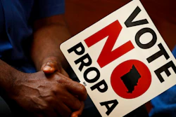 In this Tuesday, July 31, 2018, file photo, people opposing Proposition A listen to a speaker during a rally in Kansas City, Mo. Missouri votes Tuesday, Aug. 7 on a so-called right-to-work law, a voter referendum seeking to ban compulsory union fees in all private-sector workplaces.