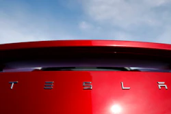 In this April 15, 2018, file photo, the sun shines off the rear deck of a roadster on a Tesla dealer's lot in the south Denver suburb of Littleton, Colo. Tesla’s second-quarter revenue should grow by more than $1 billion as it delivered more Model 3 electric cars. But analysts predict it won’t be enough to stop the company’s net loss from rising dramatically when the Palo Alto, Calif., company reports earnings after the bell Wednesday, Aug. 1.