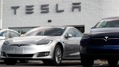 In this July 8, 2018, photo, 2018 Model 3 sedan sits next to a Model X on display outside a Tesla showroom in Littleton, Colo. Board members at Tesla are evaluating CEO and Chairman Elon Musk’s $72 billion proposal to take the electric car and solar panel maker private. Six of nine members say in a statement Wednesday, Aug. 8, that Musk began talking with the board about the move last week.