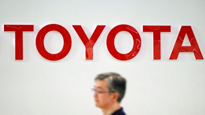 A visitor walks through a Toyota showroom in Tokyo Friday, Aug. 3, 2018. Toyota Motor Corp. has reported its quarterly profit climbed 7.2 percent, helped by strong sales in the U.S. and other overseas markets.