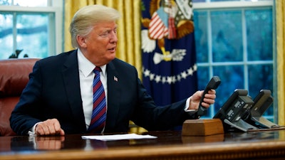 President Donald Trump hangs up after talking with Mexican President Enrique Pena Nieto on the phone in the Oval Office of the White House, Monday, Aug. 27, 2018, in Washington.