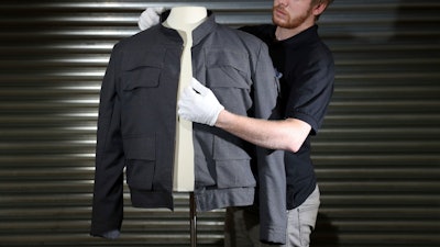 Prop Store employee James Chapman adjusts Han Solo's jacket, as worn by Harrison Ford in Star Wars.