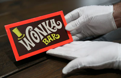 A Prop Store employee holds a Wonka Bar from the film Willy Wonka & the Chocolate Factory (estimate $10,000-$13,000) on display in the Prop Store head office.