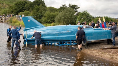 The restored Bluebird K7, which crashed killing pilot Donald Campbell in 1967, takes to the water for the first time in more than 50 years off the Isle of Bute on the west coast of Scotland, Saturday Aug. 4, 2018. The famed jet boat Bluebird has returned to the water for the first time since a 1967 crash that killed pilot Donald Campbell during a world speed-record attempt. Watched by Campbell's daughter Gina Campbell, the restored Bluebird was lowered Saturday into Loch Fad on Scotland's Isle of Bute, where it will undergo low-speed tests.