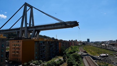 A view of the evacuated houses built under the remains part of the collapsed Morandi highway bridge, in Genoa, northern Italy, Wednesday, Aug. 15, 2018. A bridge on a main highway linking Italy with France collapsed in the Italian port city of Genoa during a sudden, violent storm, sending vehicles plunging 90 meters (nearly 300 feet) into a heap of rubble below.