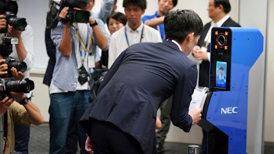 A staff demonstrates a new face recognition system used for the Tokyo 2020 Olympic and Paralympic Games during a press conference in Tokyo Tuesday, Aug. 7, 2018. The NeoFace technology developed by NEC Corp. will be used across the Olympics for the first time as Tokyo organizers work to keep security tight and efficient at dozens of venues during the 2020 Games.
