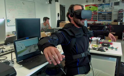 Robotics expert on the Ecole Polytechnique Federal de Lausanne, EPFL team, Matteo Macchini, displays the fly controls in a virtual reality scenario as he controls the flight of a drone, July 23, 2018, in Lausanne, Switzerland. Scientists, engineers and robotics experts at the Swiss university have teamed up to develop a jacket that allows hands-free, torso-controlled flying of drones.