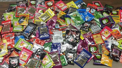 This photo provided by New York Police Department shows packets of synthetic marijuana seized after a search warrant was served at a newsstand in Brooklyn, New York.