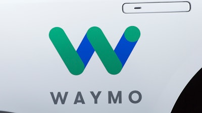 This March 27, 2018, file photo shows the Waymo logo on the of a Jaguar I-Pace vehicle, in New York. Google spinoff Waymo and Phoenix's major transit agency are partnering to test self-driving vehicles that would also boost public transportation use. Waymo announced in a blog post the start of a pilot program Tuesday, July 31, that would allow riders to hail an autonomous car to the nearest Valley Metro transit stop.