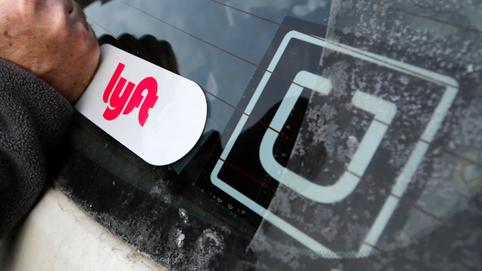 In this Jan. 31, 2018, file photo, a Lyft logo is installed on a Lyft driver's car next to an Uber sticker in Pittsburgh. The “gig” economy might not be the new frontier for America’s workforce after all. From Uber to Lyft to TaskRabbit to YourMechanic, so-called gig work has been widely seen as ideally suited for people who want the flexibility and independence that traditional jobs don’t offer. Yet the evidence is growing that over time, they don’t deliver the financial returns many expect.